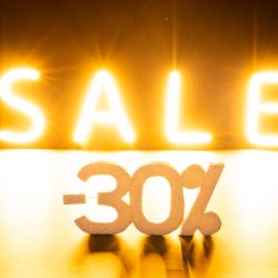 Image of glowing neon minus 30 percent sale text over orange background. Retail, savings, shopping, light and colour concept.